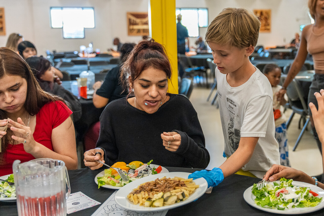 Elliot serves food to a guest at FEM.