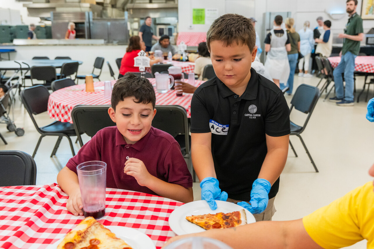 The Steads serve pizza to a family at FEM.