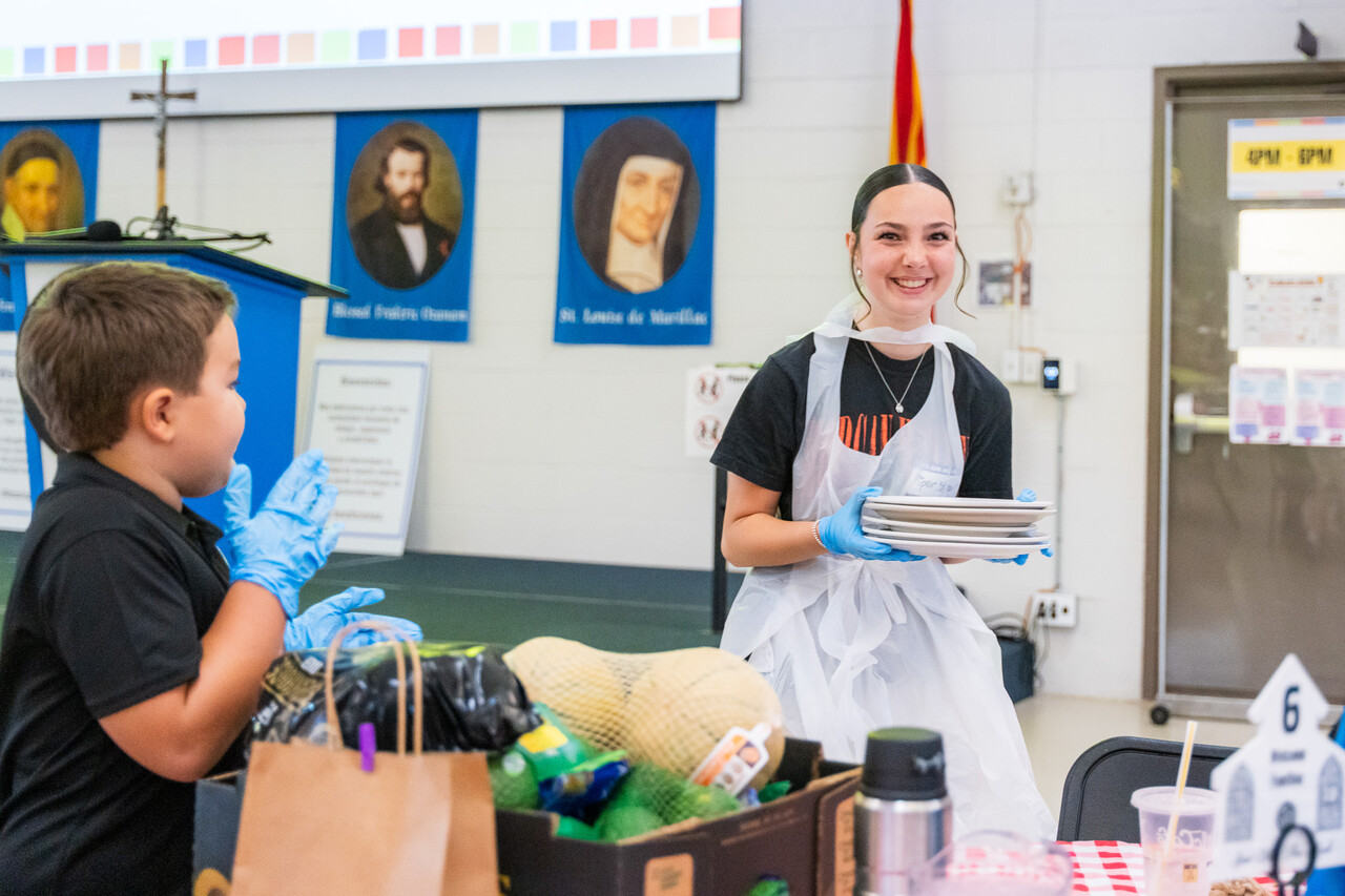 The Steads serve pizza to a family at FEM.