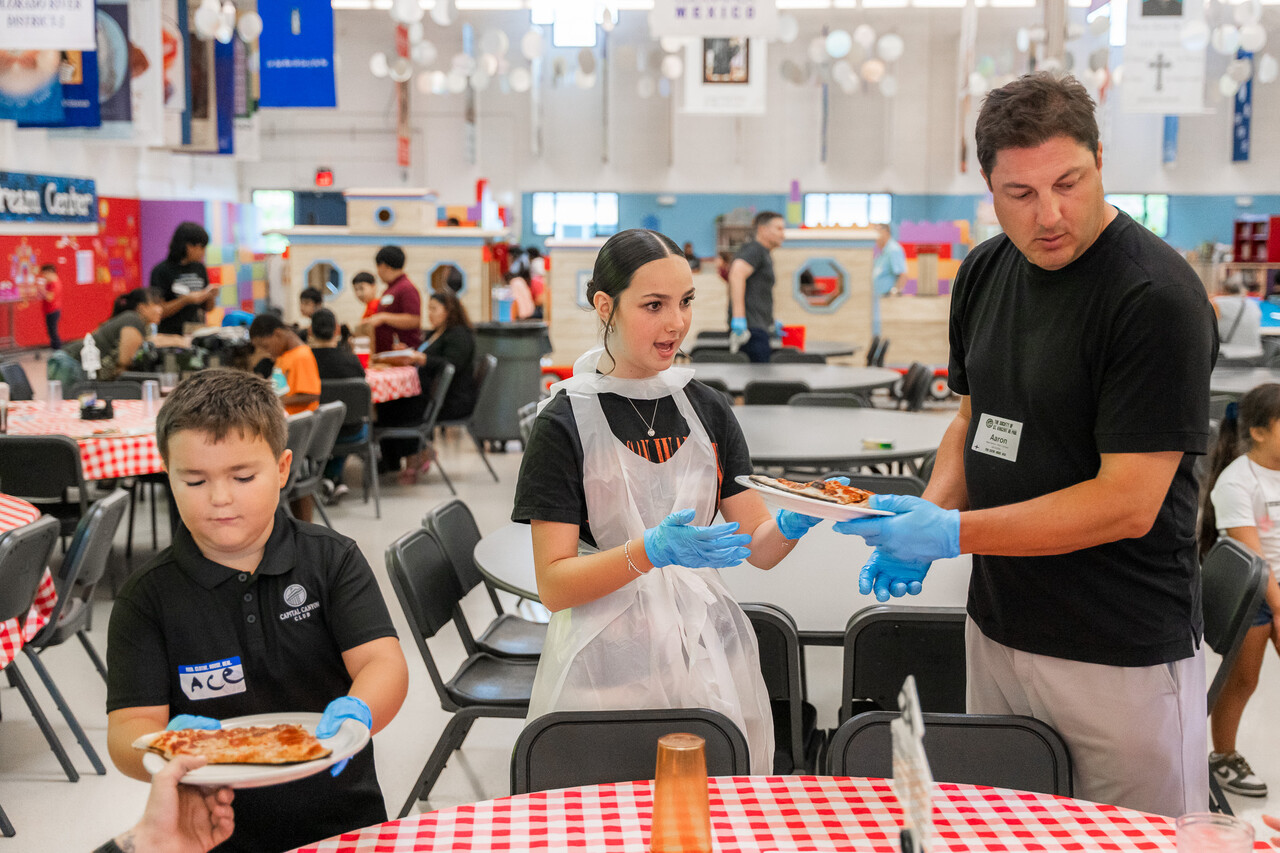 The Steads serve pizza to a family at FEM.